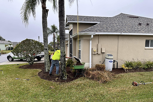 Employee of Wesley Chapel Lawn Care Company Cleaning Up on a Residential Lot